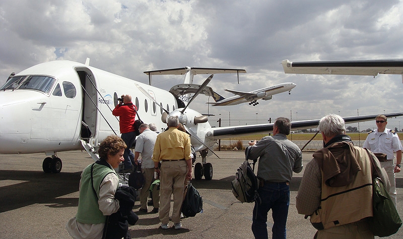 airport3.jpg - Our Federal Air Beachcraft while a Singapore Airlines 777 takes off in the background.